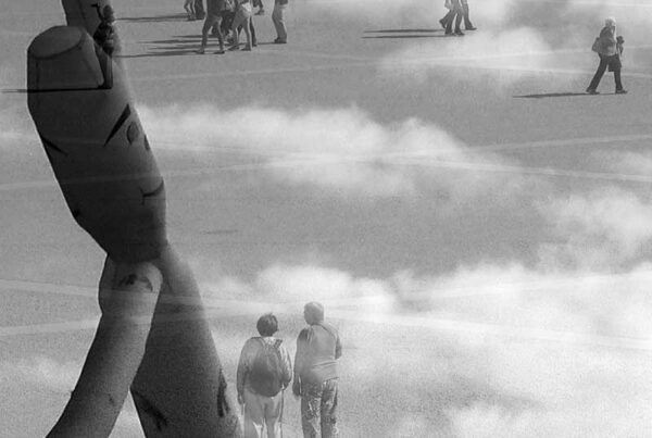 Imágenes entrelazadas en blanco y negro; en la imagen de fondo aparecen personas caminando que se mezcla con la escena de una muñeco hinchable que se mueve con el aire sobre un cielo de nubes.