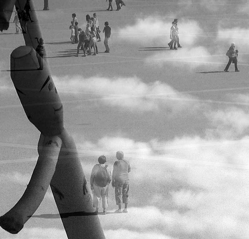 Imágenes entrelazadas en blanco y negro; en la imagen de fondo aparecen personas caminando que se mezcla con la escena de una muñeco hinchable que se mueve con el aire sobre un cielo de nubes.