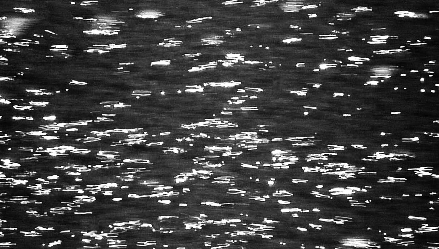 imagen en blanco y negro de destellos en el mar